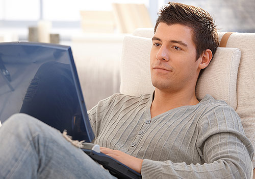 Young man watching tv on couch